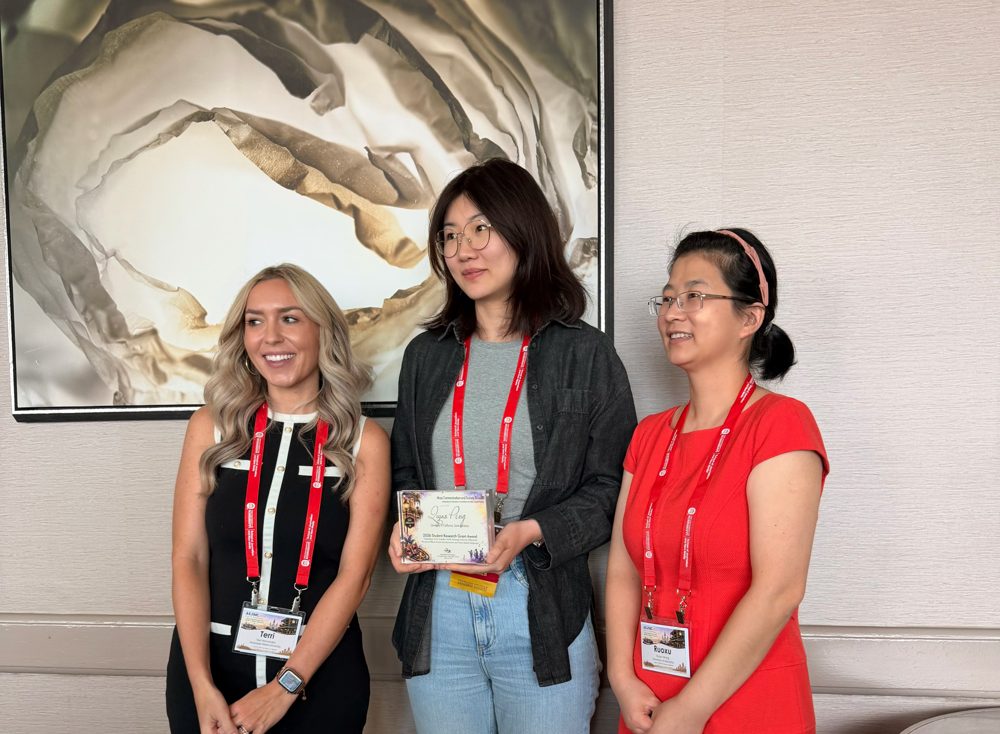 Qiyao Peng receiving the AEJMC Mass Communication and Society Division Student Research Award in New Orleans