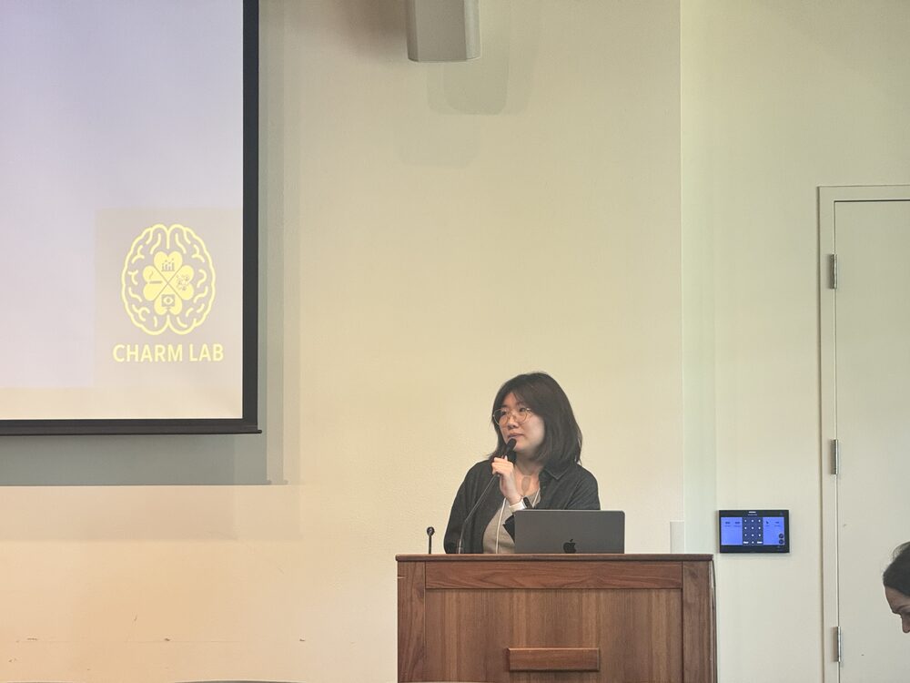 Qiyao Peng at the podium with CHARM Lab logo, Comm Horizons UC Davis